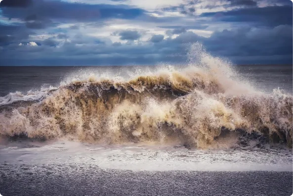 A wave crashes onto a sandy beach